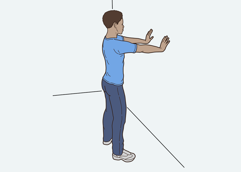 Το άτομο στέκεται όρθιο με τα χέρια του επίπεδα σε ένα τοίχο.