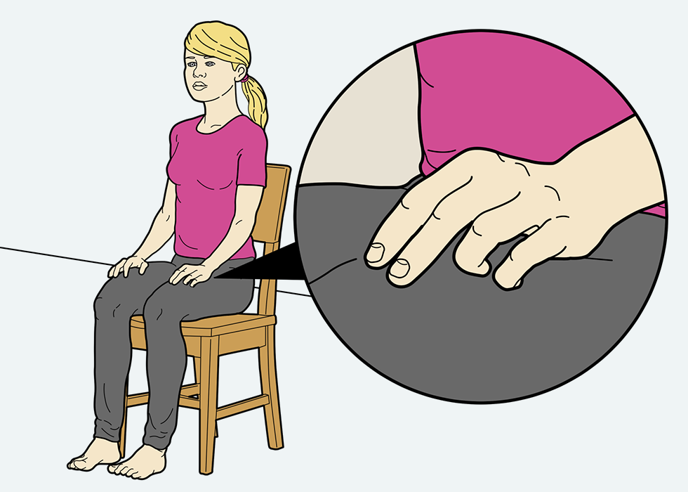 Άτομο κάθεται σε μια καρέκλα και ακουμπά δύο δάχτυλα στο πάνω μέρος του ποδιού του.